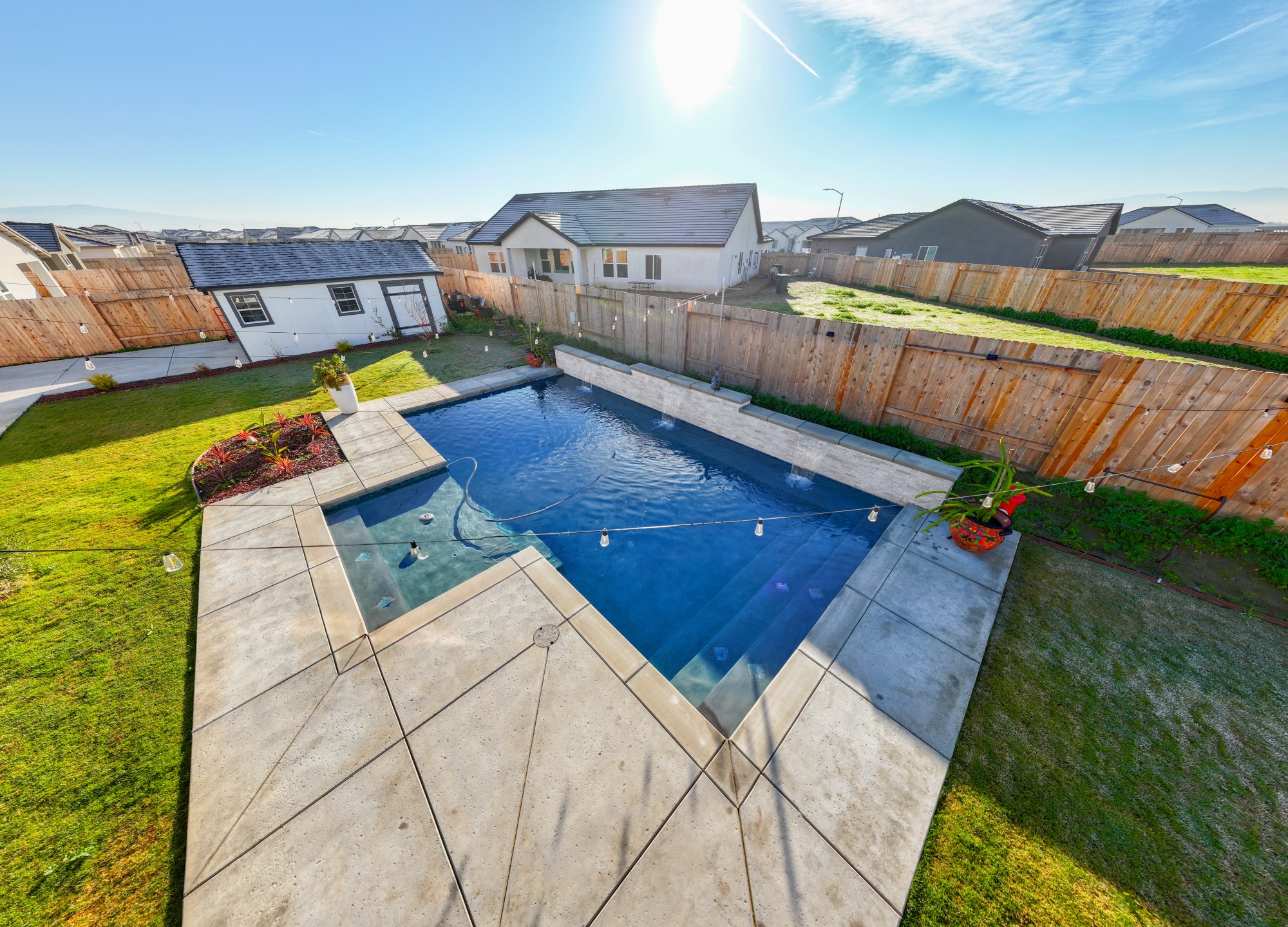 Aerial view of custom gunite pool with wide concrete deck