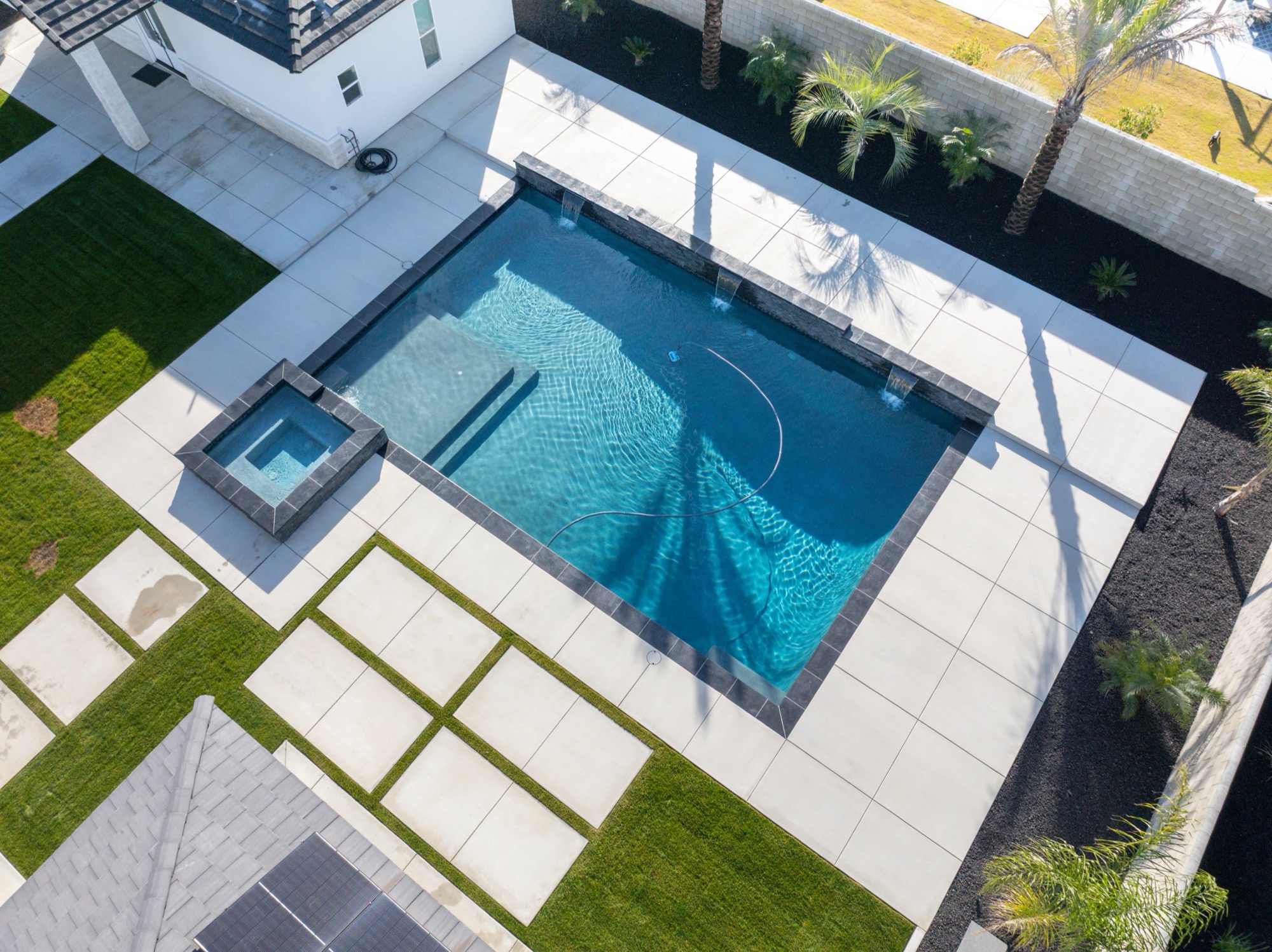 Aerial view of custom gunite pool with modern home