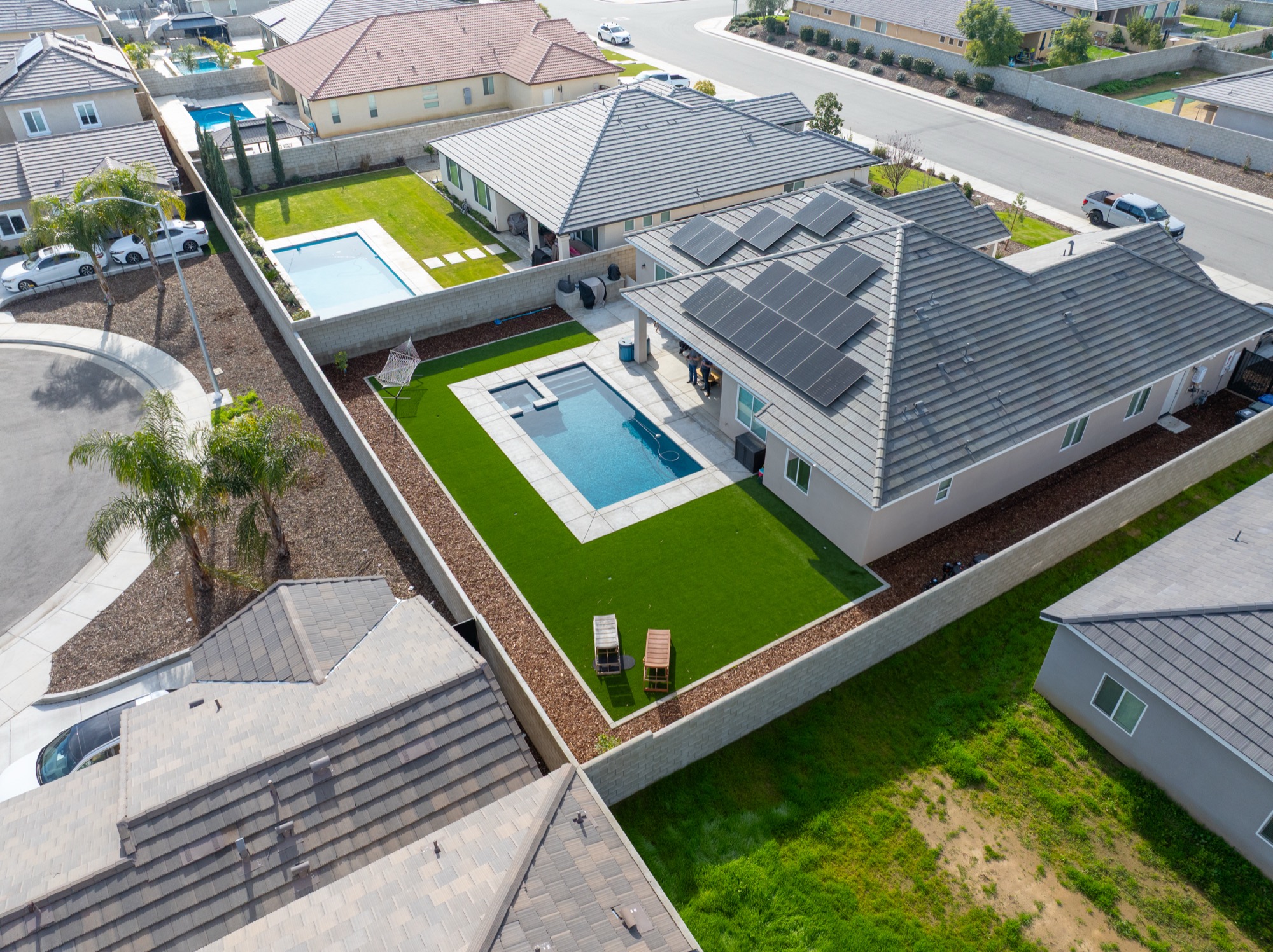 Aerial view of custom gunite pool with spa, solar, and turf yard in Bakersfield
