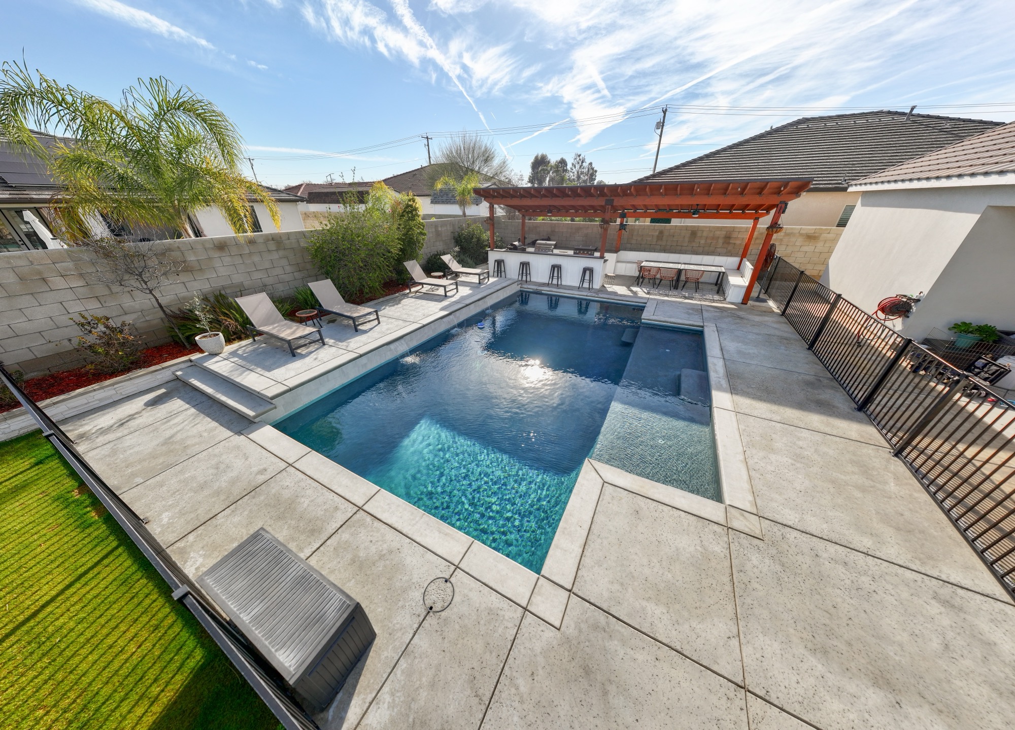 Custom gunite pool with pergola, outdoor bar, and loungers in Bakersfield