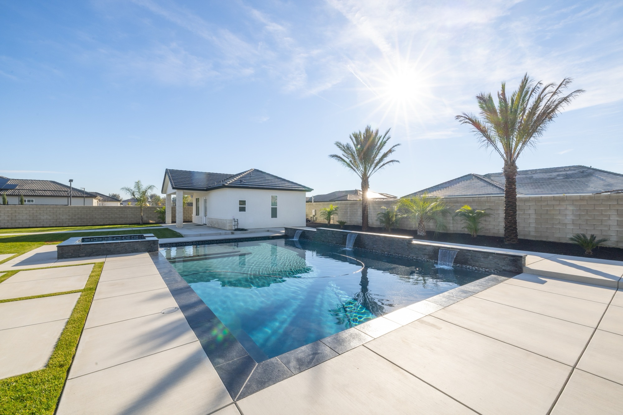 Custom gunite pool with spa, palms, and modern home in Bakersfield