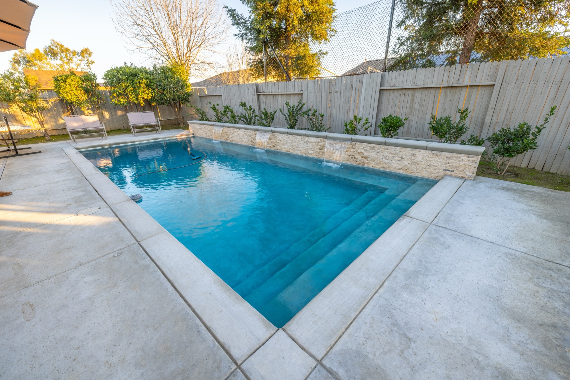 Custom gunite pool with stone spillway wall — Bakersfield, CA